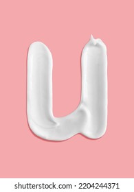 Alphabet Letter U Handwritten, White Cream Moisturiser Texture Smear Stroke Isolated On Pink Background
