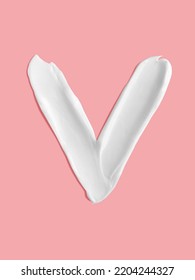 Alphabet Letter V Handwritten, White Cream Moisturiser Texture Smear Stroke Isolated On Pink Background
