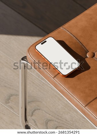 App or website presentation mockup featuring a phone with a blank screen on a minimalist leather bench.