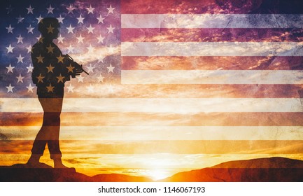 Armed soldier with rifle standing and looking on horizon. USA flag. Silhouette at sunset. War, army, military, guard.