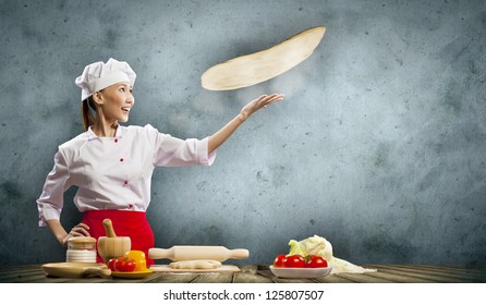 Asian Female Cook Making Pizza Standing Against Color Background