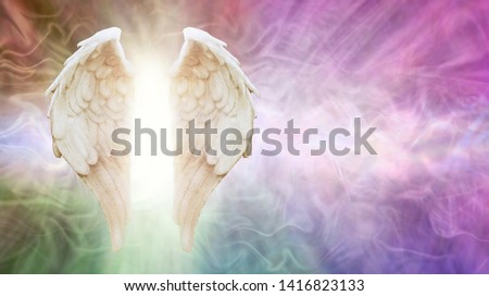 Ask Your Angels Message Background - beautiful Angel wings with white light between against a flowing multicoloured energy formation background with copy space

