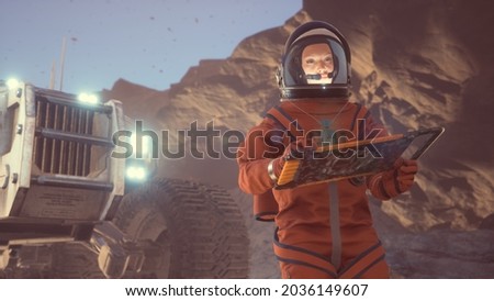 An astronaut is working at a computer next to his rover on an alien, unexplored desert planet. 3D Rendering