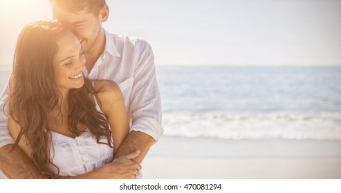 Attractive couple cuddling at the beach - Powered by Shutterstock