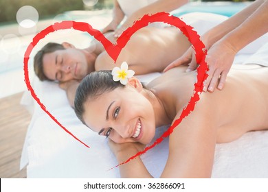 Attractive couple enjoying couples massage poolside against heart - Powered by Shutterstock