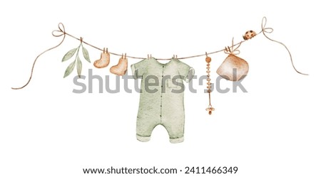Baby clothes hang on the clothesline. Things are dried on clothespins after washing.