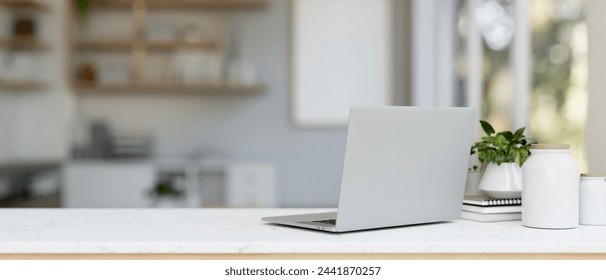 A back view image of a laptop computer and decor on a white table in a modern and clean office. close-up image. 3d render, 3d illustration