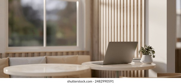 A back view image of a laptop computer on a table in a modern, comfortable cafe seating area. 3d render, 3d illustration