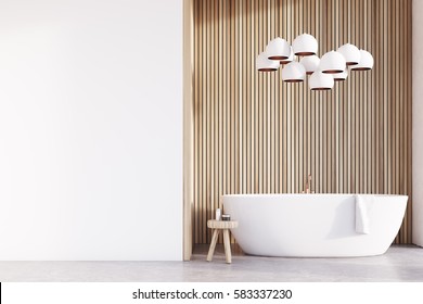 Bathroom interior with a tub, a chair with body care products, a light wooden wall and a lamp resembling grapes hanging above it. White wall fragment. 3d rendering.  Mock up.