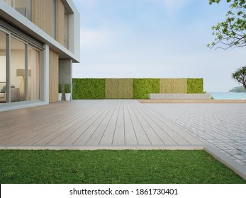 Beach house with wooden terrace near empty cobblestone floor for car park. 3d rendering of green grass lawn in modern sea view home.