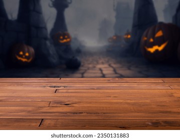 Beautiful brown plank wooden table or desk floor, little shiny surface, perspective view,  blurred image of Halloween evil pumpkins and creepy graveyard at night for background. - Powered by Shutterstock