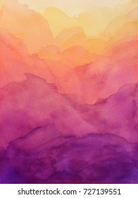 Beautiful Hues Of Yellow Gold Pink And Purple In Hand Painted Watercolor Background Design With Paint Bleed And Fringing In Colorful Sunrise Or Sunset Colors In Abstract Cloudy Mountain Shapes.