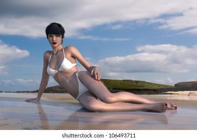 A beautiful young woman relaxes on the beach