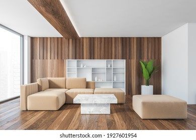 Beige Corner Sofa With White Marble Coffee Table In Wooden Living Room, Parquet Floor And Wooden Wall. Couch And Beige Seat With Plant, Shelf In Wall And Window, 3D Rendering No People