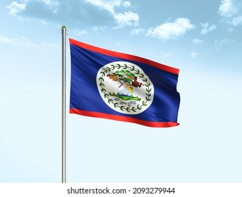 Belize flag waving on blue sky background with clouds. Close up waving flag of Belize. Belize flag waving in the wind.