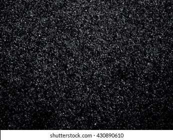 Black sand texture. Dark soil background. Fine suspension forms surface. 