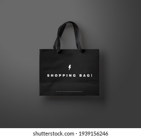Black shopping bag on black background. Advertising and branding