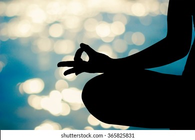 black silhouette asian woman concentrate by raise hand gesture in yoga pattern on blurred calmness sea ocean with sunset light background for healthy lifestyle and strength concept. - Powered by Shutterstock