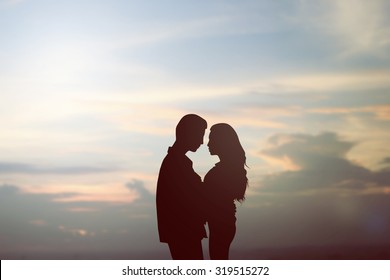 black silhouette teenager lovers couple dating in romantic moment on sunset spring sky background at the beach - Powered by Shutterstock