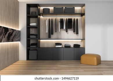 Black wardrobe with clothes standing in stylish bedroom interior with white and wooden walls, wooden floor and leather armchair. 3d rendering