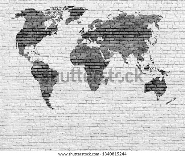 Black and white world map on brick wall background.