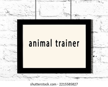 Black Wooden Frame With Inscription Animal Trainer Hanging On White Brick Wall 