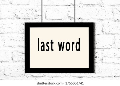 Black Wooden Frame With Inscription Last Word Hanging On White Brick Wall 