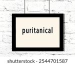 Black wooden frame with inscription puritanical hanging on white brick wall 