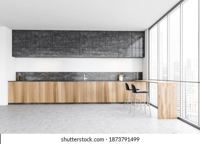 Black and wooden kitchen with two black bar chairs and counter, window on city with skyscrapers. Luxury dark minimalist kitchen with marble floor 3D rendering, no people