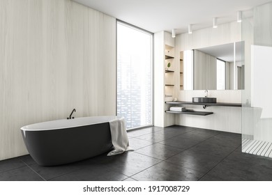 Black And Wooden White Minimalist Bathroom With Sink And Mirror, Black Bathtub Near Window, Side View. Modern Minimalist Bathroom On Black Tiled Floor, 3D Rendering No People