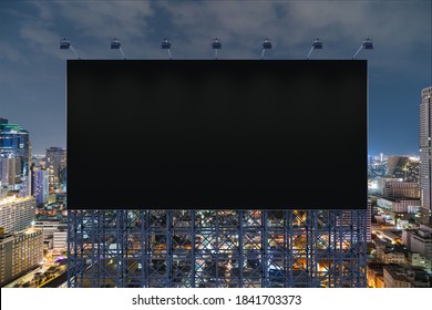 Blank black road billboard with Bangkok cityscape background at night time. Street advertising poster, mock up, 3D rendering. Front view. The concept of marketing communication to sell idea. - Powered by Shutterstock