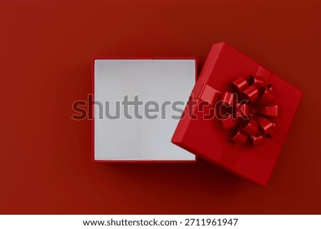Blank red rectangle gift box mock up open or top view of white present box product display showcase frame tied with red ribbon bow resting on a vibrant red background.