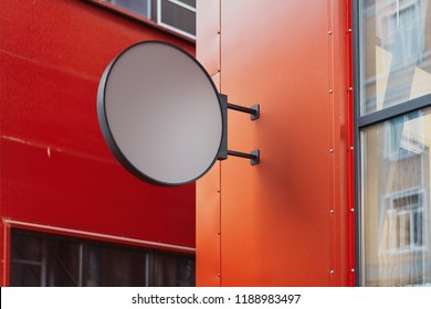 Blank Round Store Signboard Mockup. Empty Circular Illuminated Shop Lightbox Template Mounted On The Red Wall. Street Sign, Signage, 3d Rendering.