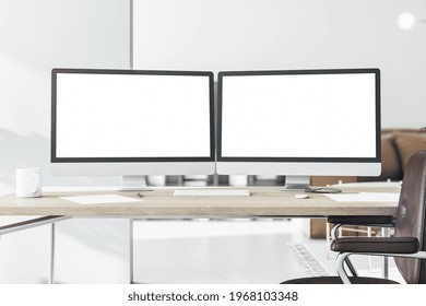 Blank White Computer Monitors On Light Wooden Table With Keyboard And Brown Leather Chair Near. 3D Rendering, Mockup