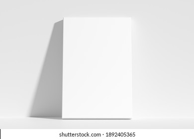 Blank white empty vertical rectangular poster on floor leaning at empty white wall, white bleached colorless poster mock-up, 3D Illustration