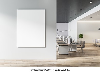 Blank white poster on light grey wall in modern open space office with light furniture and wooden floor. Mock up. 3D rendering