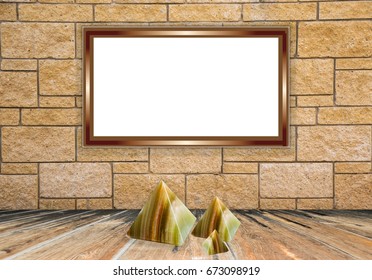 Blank white screen with a beige frame in light natural brick wall and the three pyramids from natural onyx stone in the center on a wooden table, mock up