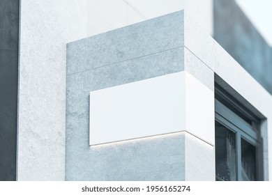 Blank White Signage With Backlight On The Corner Of Modern Concrete Building Near Entrance, 3D Rendering, Mockup