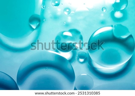 A blue abstract image created by dripping oil on the surface of water is a unique background.