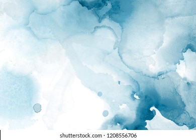 Blue alcohol ink wash texture on white paper background. Liquid paint flow. Transparent ethereal effect.