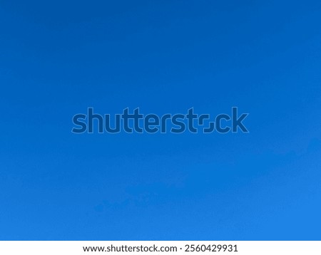 Blue background. The sky is blue and clear without clouds. The sun shines brightly, making the sky look brighter. The view is peaceful and calm