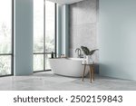 Blue corner view of hotel bathroom interior with bathtub and side table, tile concrete floor. Bathing corner in modern apartment. Panoramic window on tropics. 3D rendering