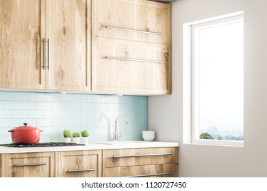 Blue Tile Kitchen Interior With Wooden Countertops And Cabinets, A Red Cooking Pot And Several Potted Plants. A Window. 3d Rendering Mock Up