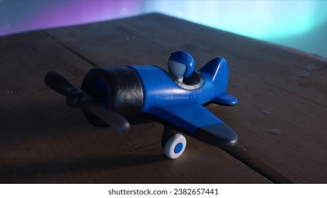 A blue toy airplane for boys with a pilot inside on a wooden table. The cosmic environment and the northern lights. The concept of aviation. 3D illustration - Powered by Shutterstock