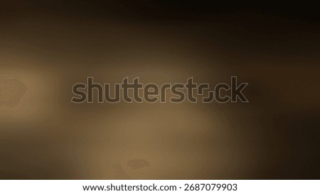 A blurred image featuring a blend of brown and dark tones creating a soft, gradient background effect.