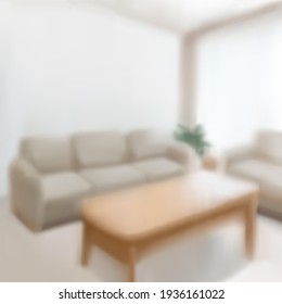 Blurred interior of living room with sofa set and wooden center table in 3D illustration