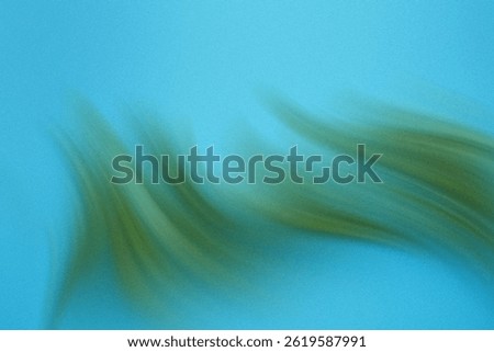A blurry abstract image featuring a gradient of blue and green colors creating a soft and dreamy effect