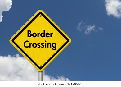 Border Crossing Road Sign, Yellow Caution Sign With Word Border Crossing With Sky Background