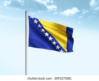 Bosnia and Herzegovina flag waving on blue sky background with clouds. Close up waving flag of Bosnia and Herzegovina. Bosnia and Herzegovina flag waving in the wind. - Shutterstock ID 2093275081