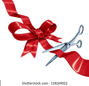 Bow and ribbon cutting with a red silk gift wrapping decoration with scissors opening the packaging as a holiday symbol for Christmas a birthday or valentine's day isolated on a white background